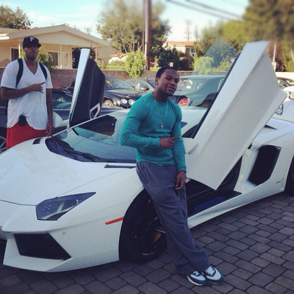Floyd with white Lamborghini Aventador, mini afro, green shirt and jeans