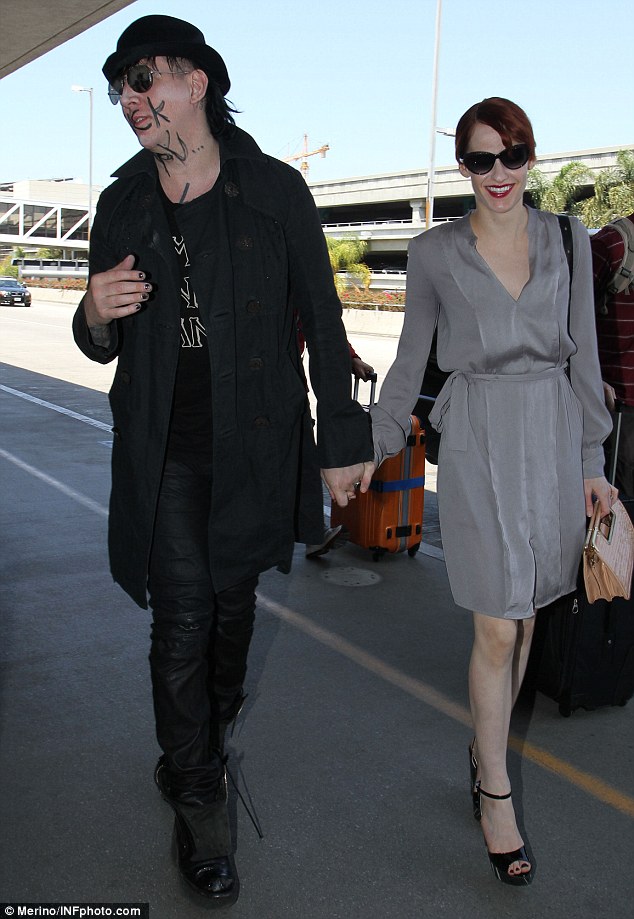 manson dressedin all black with girlfriend Lindsay Usich smiling and walking together