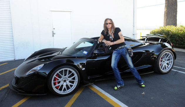 steven tyler poses by his 1.1 million dollar car in flip flops