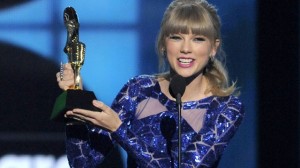 Taylor Swift holding up her Billbord Music Award May 19, 2013